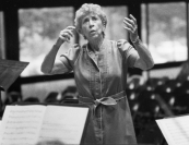 Conducting in Persons Auditorium. Both her daughter, Dr. Dominique Moyse Steinberg, and soprano Hyunah Yu tell a family story about a home cook—either Honegger Moyse herself or her mother—who was complimented on her food with the praise "it must have been made with love." The chef counters "no, it was made with butter," a metaphor for the use of judicious technique in musicianship in addition to mere emotional connection. Photo by George Dimock.